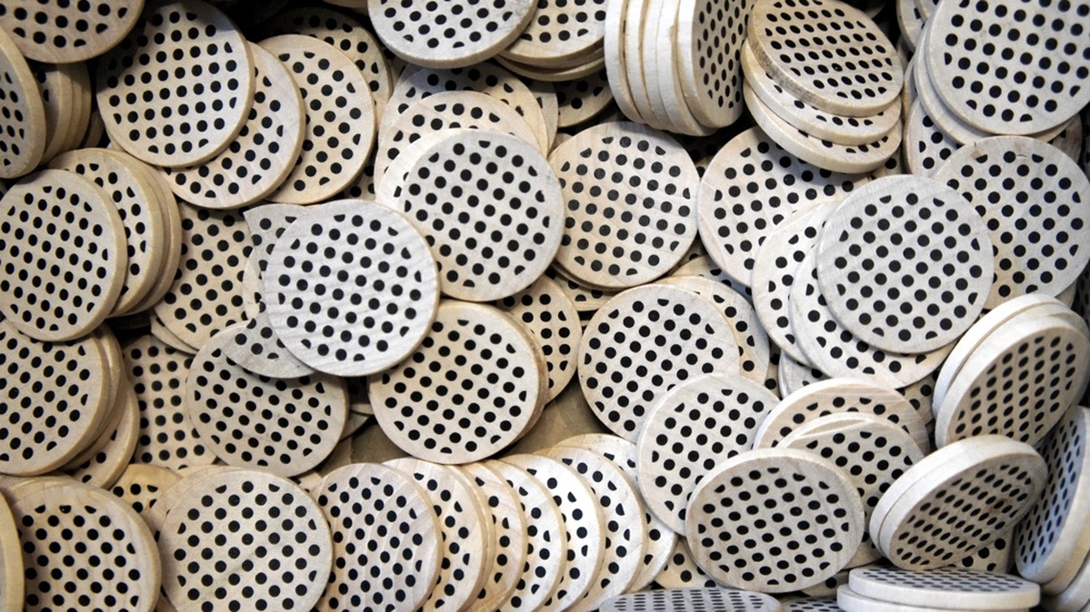 a pile of wooden tokens with OpenNews' round logo of many black dots